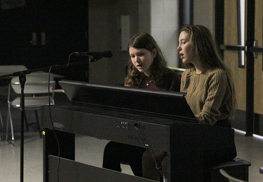 As junior Carly Tribble plays the piano, senior Julia Feuerborn sings along.