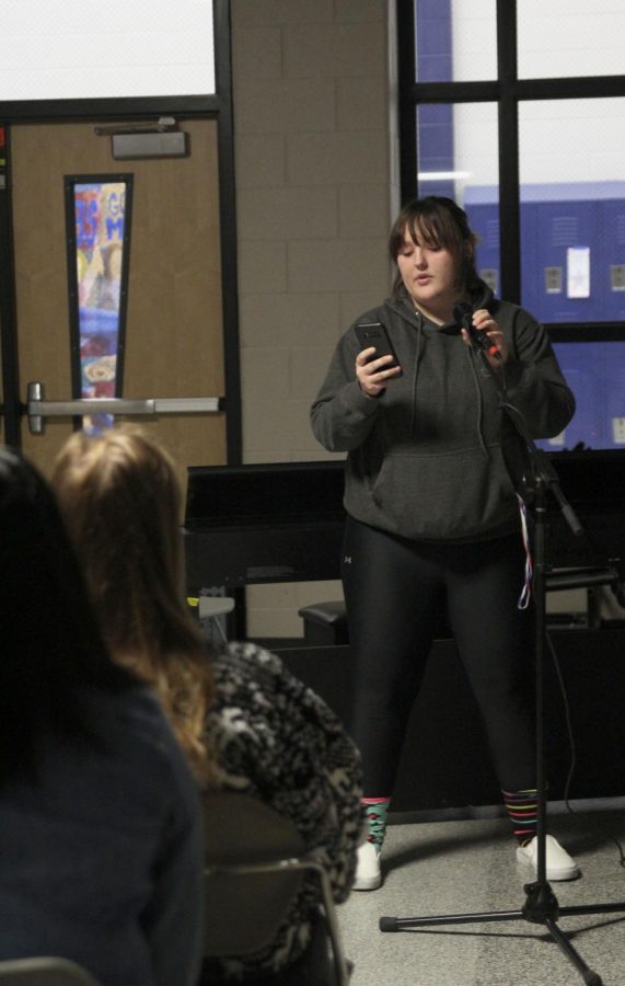 Reading the lyrics from her phone, junior Avery Sheltra performs a song. 