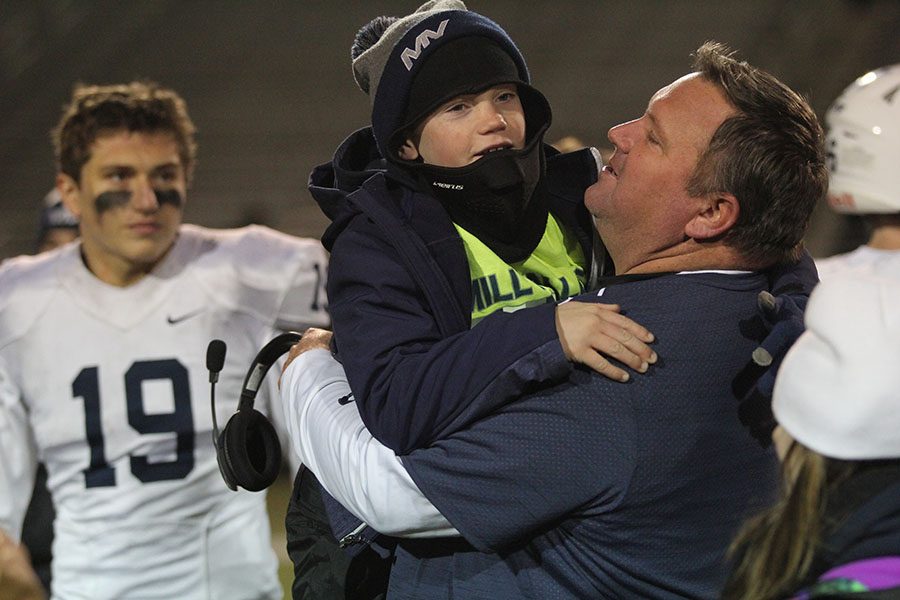 At the end of the game, offensive line coach Rick Pollard picks up his son.