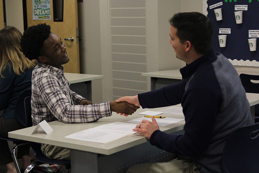 At the conclusion of his interview, senior Chris Sherald smiles as he shakes hands with his interviewer counselor Chris Wallace. 