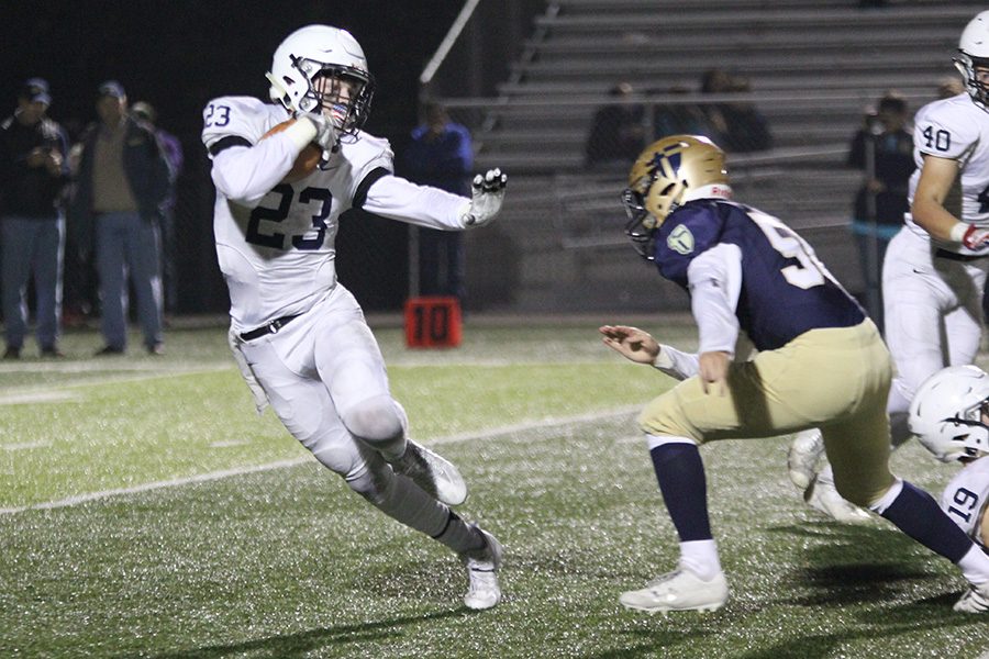 In the sub-state game against St. Thomas Aquinas on Friday, Nov. 17, the Jaguars lost 55-21. Extending his arm, junior Tanner Moore avoids a defender as he carries the ball.