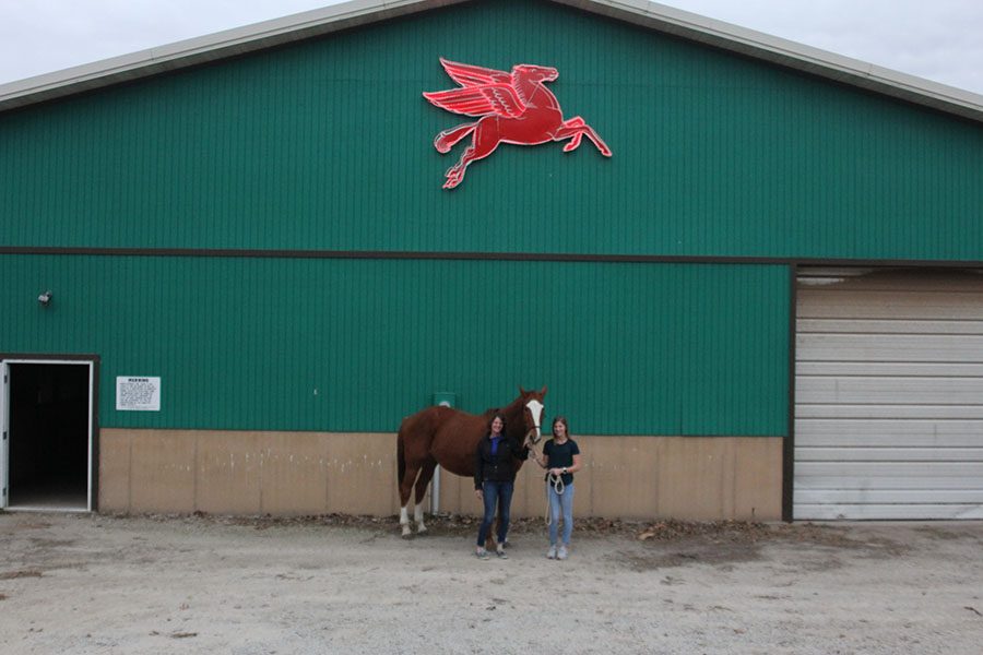 Posing in front of one of the barns, senior Britton Nelson and her mom Courtney Nelson, hold the reigns of their horse.