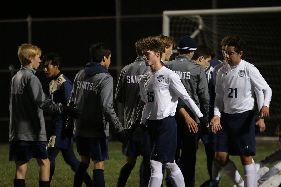 After the game, junior Brock Denney high fives Aquinas players.