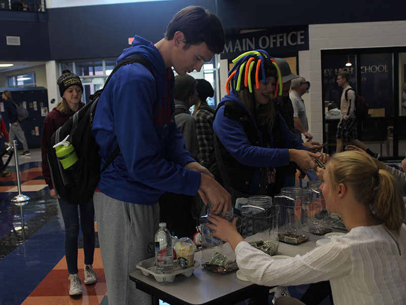 Senior Ethan Jacobs and special education teacher Amanda Appl donate coins to support Puerto Rico hurricane victims on Wednesday, Nov. 15.