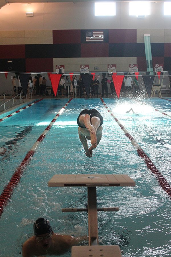 Diving into the water, junior Jakob Twigg takes over the 200 free relay from sophomore Gavin Fangman.