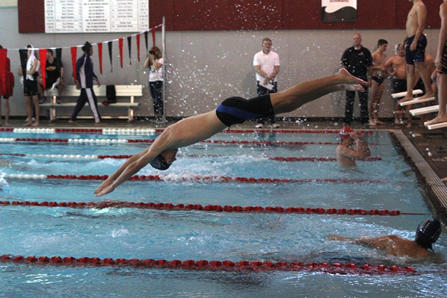 Jumping off the block, sophomore Gavin Fangman completes the second leg of the 200 free relay after freshman Cole McClure reaches the wall.