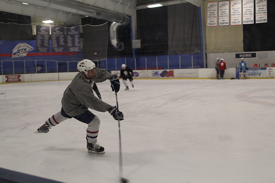 At+a+hockey+practice+on+Wednesday%2C+Nov.+30%2C+senior+Justin+Grega+passes+the+puck+to+a+team+mate+during+a+drill.+