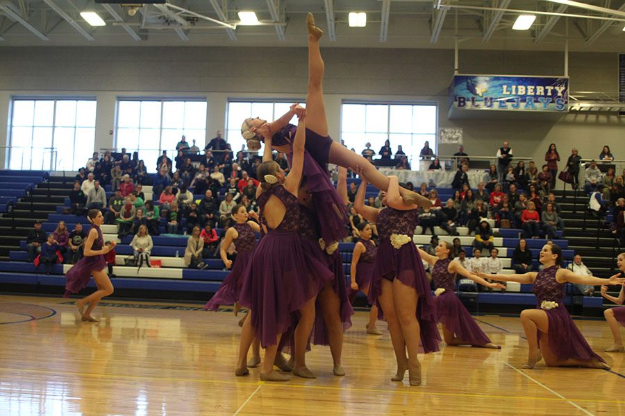 As junior Bella Line stretches her legs upward during the jazz routine, other dancers focus on her balance.