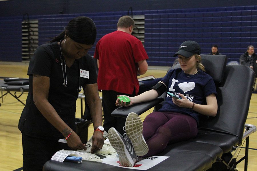 Watching the nurse prep her tools, sophomore Abbie Morgan patiently waits to have her blood drawn during the StuCo-run blood drive on Saturday, Jan. 6.