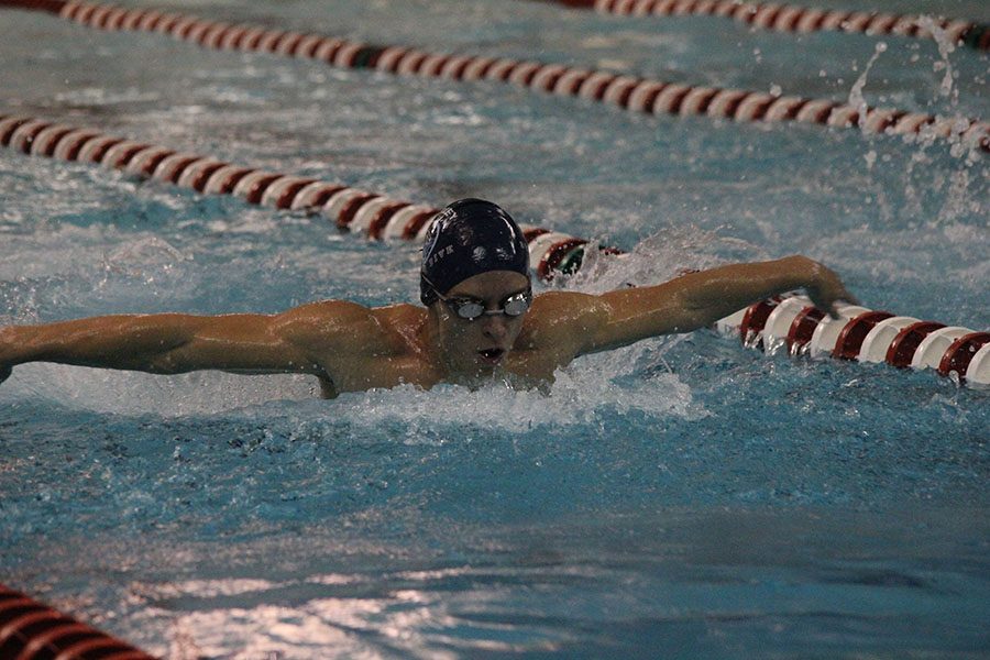 Taking a breath in between strokes, senior Carter Lawson swims the butterfly.