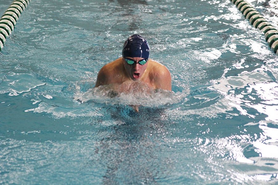 Taking a breath, junior Jakob Twigg swims a breaststroke at the Timberwolf Invitational meet on Saturday, Jan. 20.