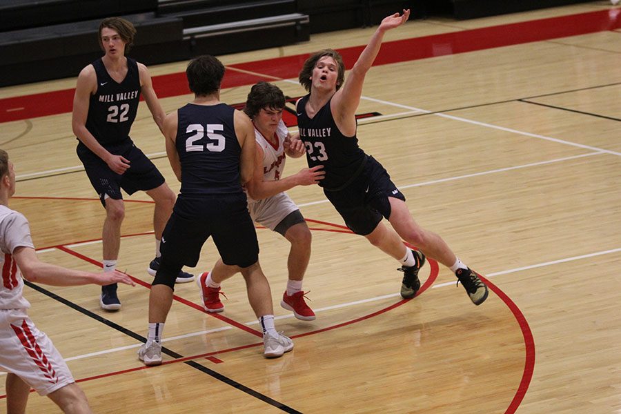 Pushing past a Lansing defender, senior Cooper Kaifes motions to his teammate to get the ball.