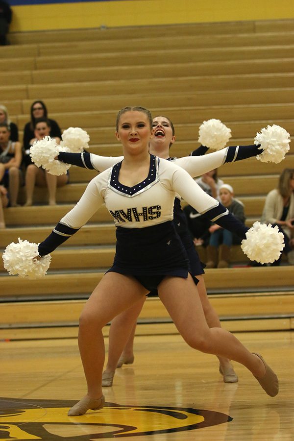 With arms outstretched, freshman Jenna Haase performs the pom routine with senior Emma Barge right behind her.