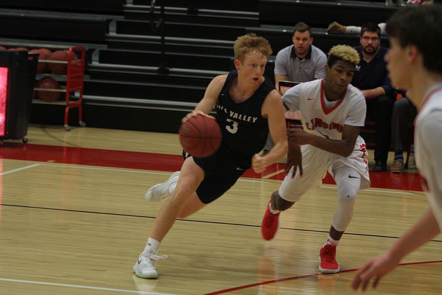 Moving towards the basket, senior Sammy Rebeck dribbles the ball.