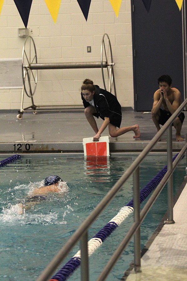 Dunking in a red lap counter to signal the last lap of the 500 free, team manager junior Carly Tribble and sophomore Tyler Draper cheer on freshman Cole McClure.