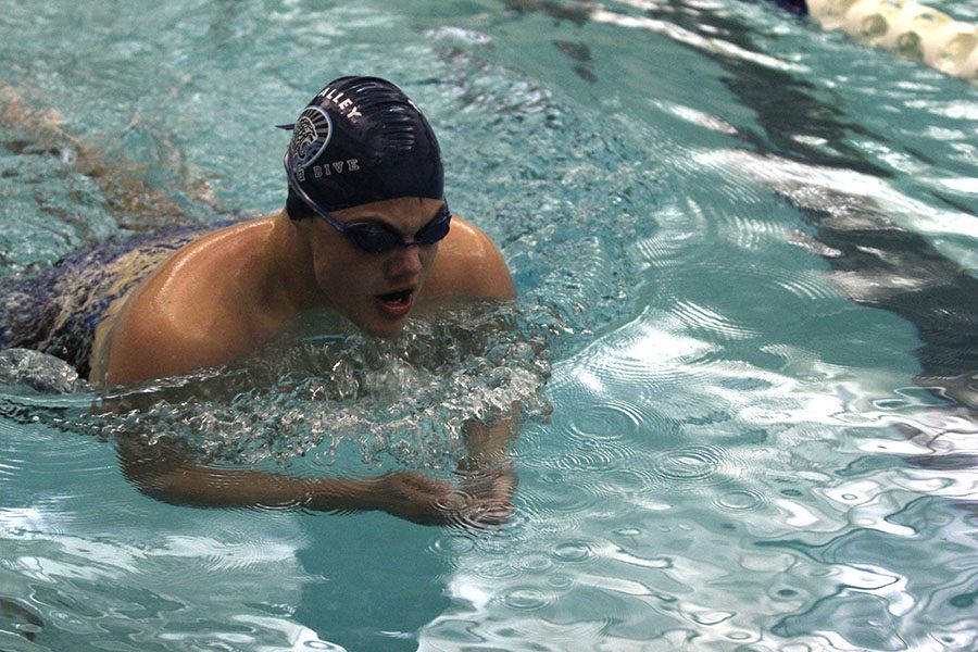 Coming up for a breath, senior Noah Kemper swims the 100 breast stroke.