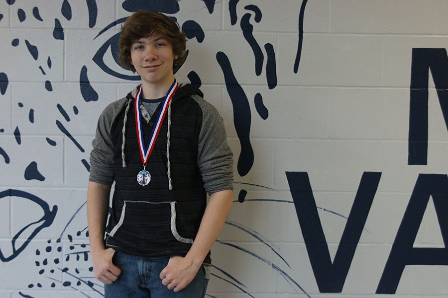 After placing fourth place at a chess competition, junior Andrew Thomas proudly displays his medal Tuesday, Jan. 22. “I started playing about eight to ten years ago and competing three to four months ago,” said Thomas. “I’ve been to one tournament and did pretty well.”