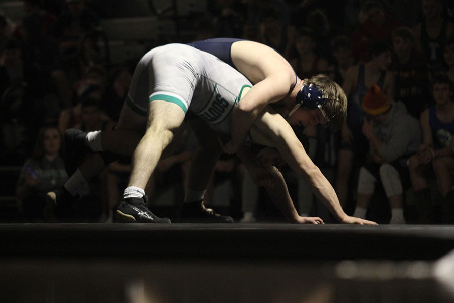As his opponent bends over, senior Hayden Keopke tries to push him to the ground.