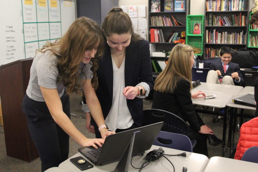 Huddled over a laptop, senior Allison Winker and junior Lauren Rothgeb prepare for the state debate competition on Friday, Jan. 12.