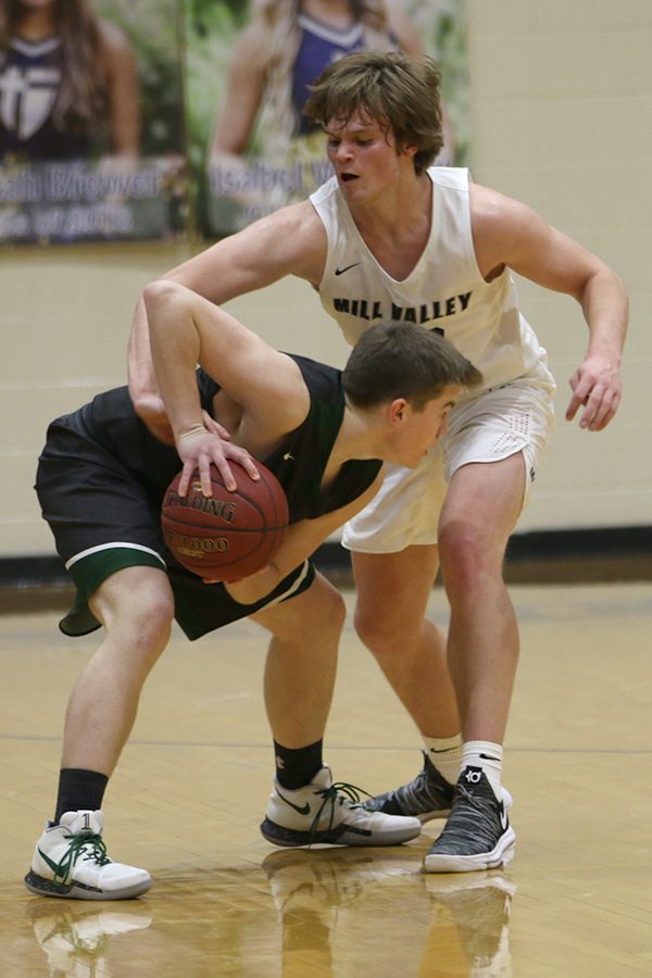 Reaching around his opponent, senior Cooper Kaifes attempts to steal the ball.