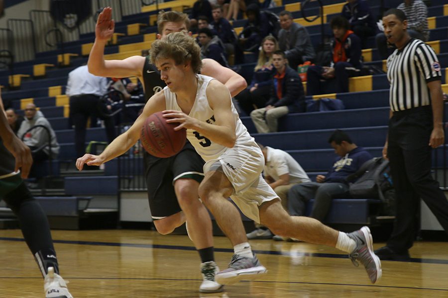 Running the play, junior Logan Talley dribbles around his defender.