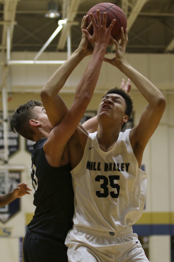 Battling against a defender, freshman Keeshawn Mason attempts to shoot.