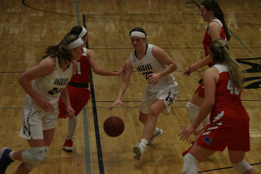 As junior Claire Kaifes tries to move through the court, she dribbles the ball.