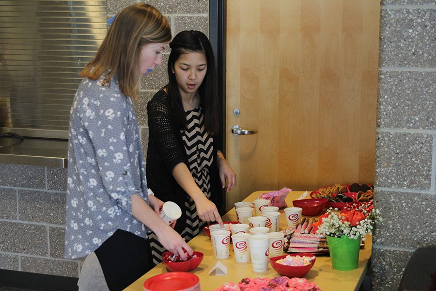 Seniors Britton Nelson and Taylor Nguyen prepare the food station.