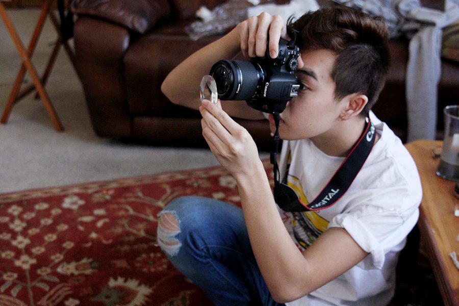 Positioning a prism in front of his camera lens, senior Simon Vongxay photographs a subject during a photo shoot on Thursday, Feb. 1.