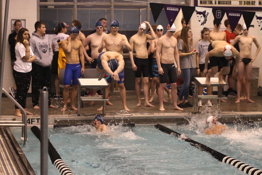 At the Eastern Kansas League finals, junior Chris Sprenger completes his leg of the 200-yard freestyle relay, and junior Ethan Forristal dives into the pool on Saturday, Feb. 3.      