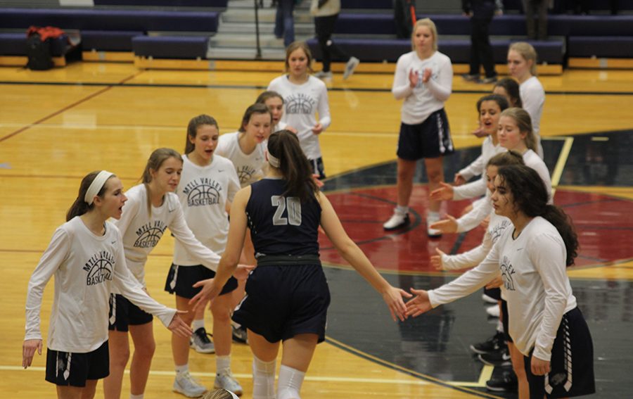 Giving high fives to her team mates, junior starter Trinity Knapp is announced before the game begins.