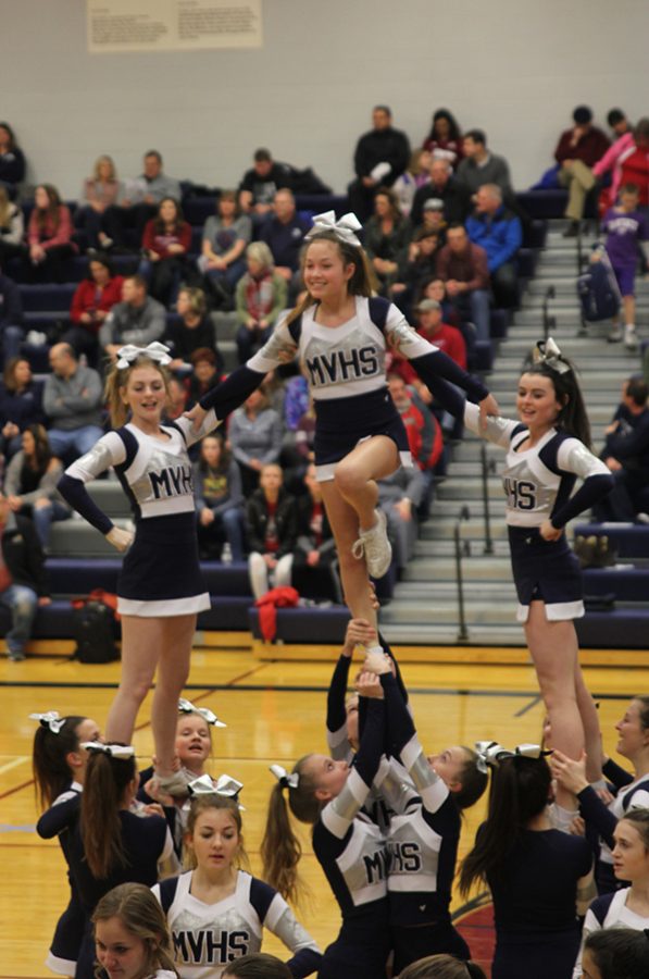 Cheerleaders pump up the visiting crowd before the game. 