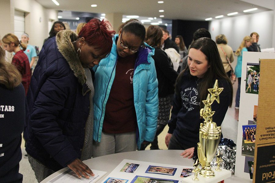 A member of the class of 2022 and her mother talk to junior Eve Steinle about joining the Silver Stars.