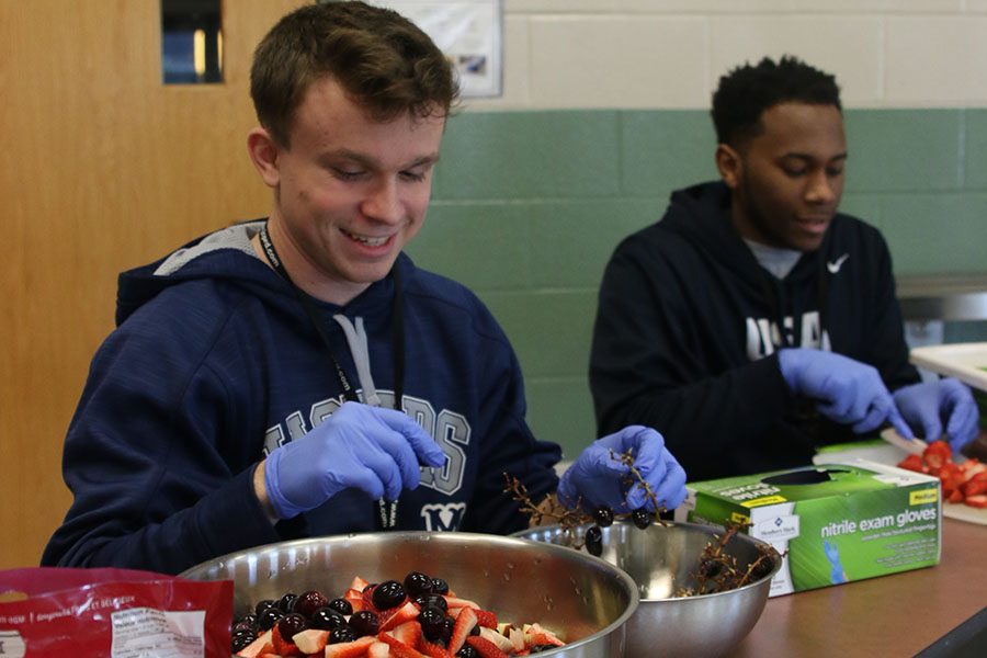 Mixing up a bowl of fruit, senior Will Morris prepares a snack at the Prairie Ridge Elementary JCPRD program on Monday Jan. 29.
