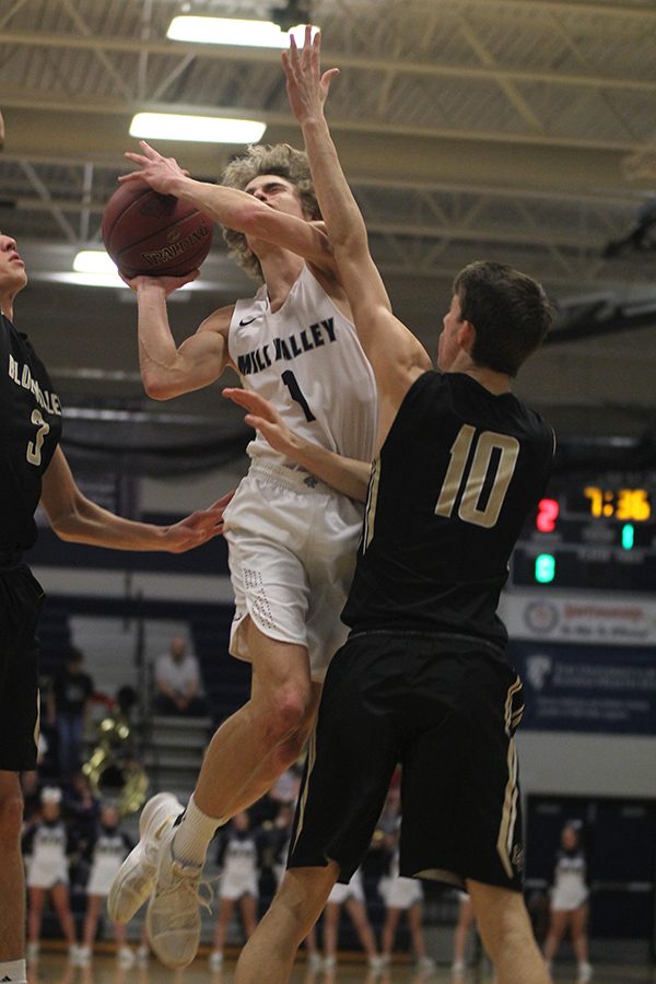 Jumping into a defender, senior Colton Hinkle attempts a shot.