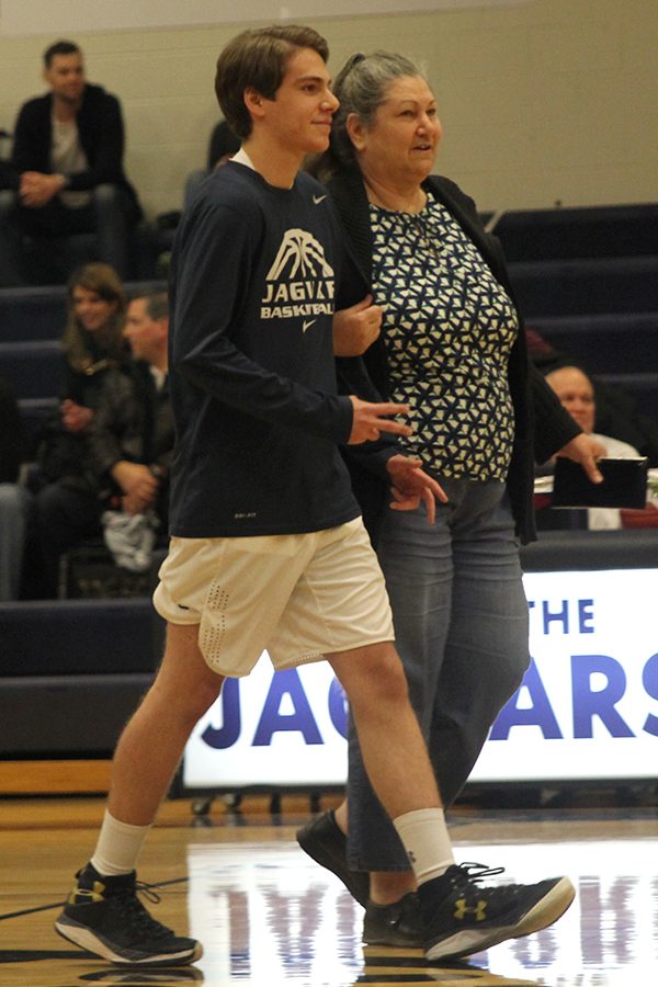 Senior Alan Williams walks out with his mom on senior night. 