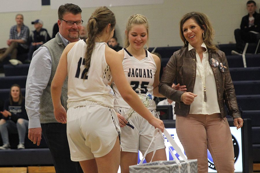 Walking with his parents, senior Payton Shurley is handed a gift basket by her sister Ella Shurley.