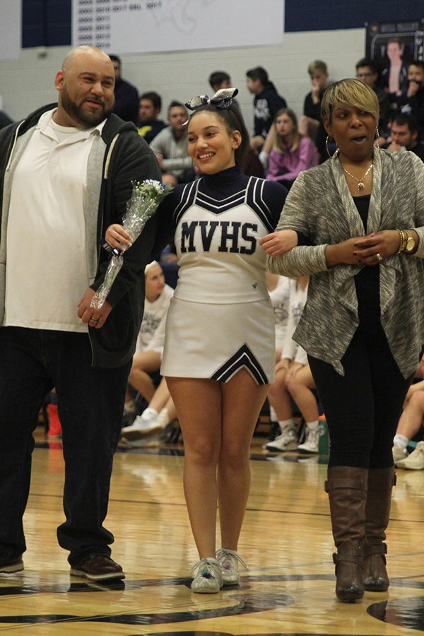 Senior Brooke Davis stands with her parents as she is recognized on senior night.