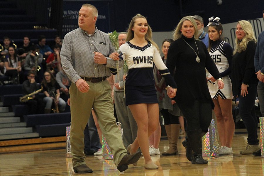 Walking with her mom and dad, senior Emmy Bidnick is honored for being a senior Silver Star.