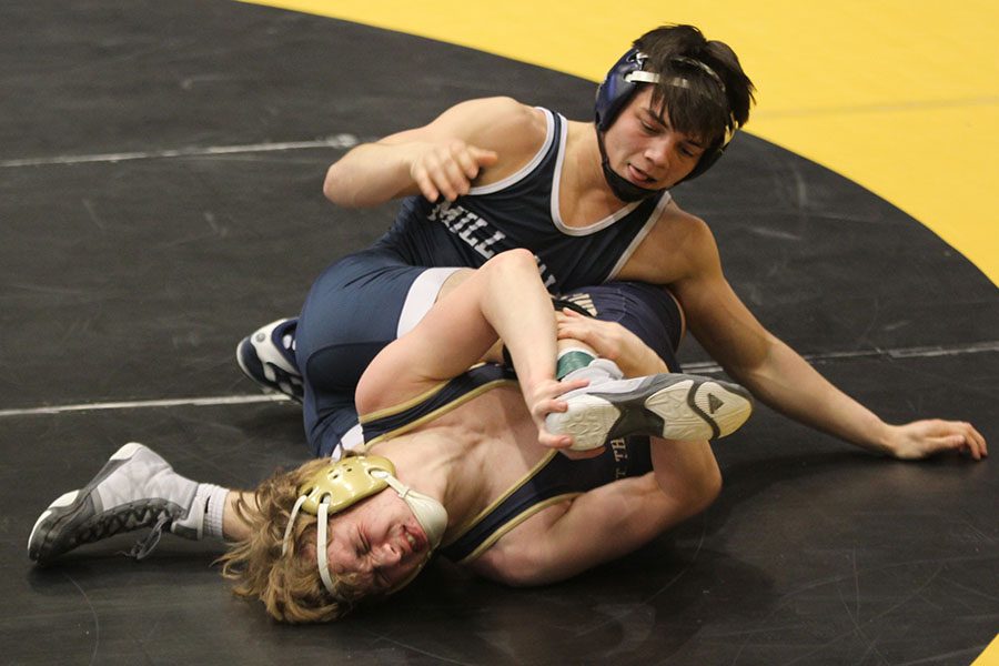 As his opponent struggles under him, senior Bryson Markovich attempts to get a pin.