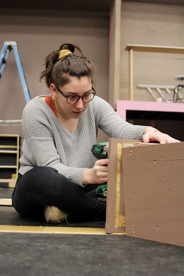During set crew on Saturday, Jan. 13, sophomore Analiese Wilhauk uses a drill to dismantle an old set piece. 