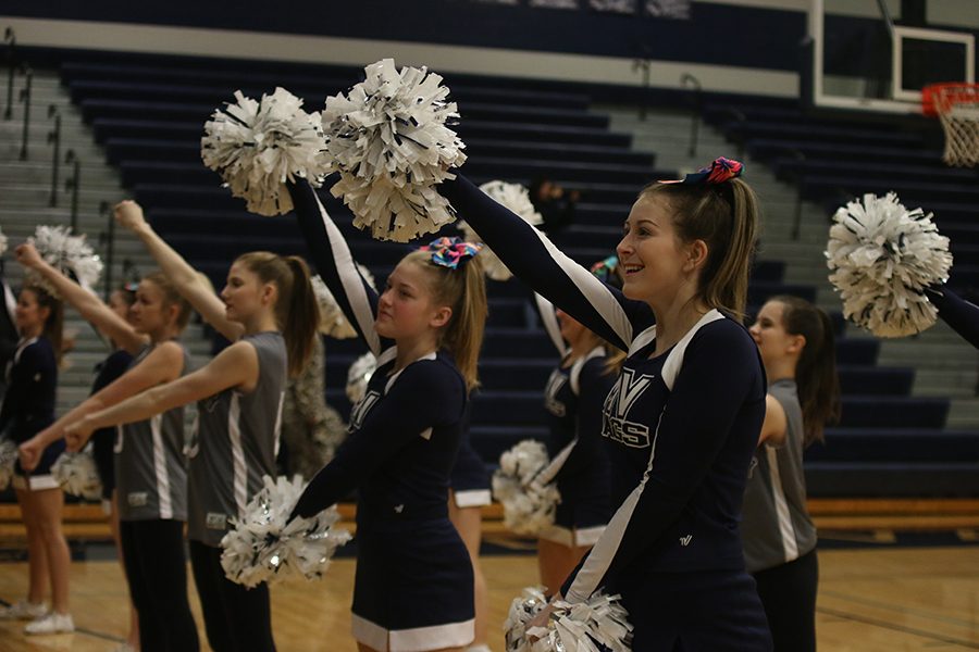 While singing the fight song, junior Lexi Knappen cheers.