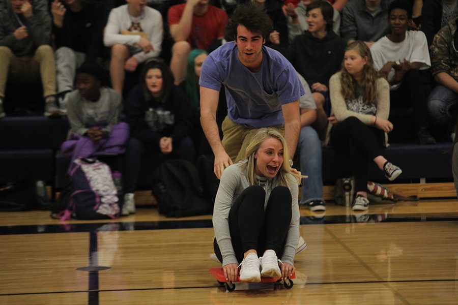 As senior Simon Stewart pushes senior Adde Hinkle, she tries not to fall on Friday, Feb. 9 at the winter homecoming pep assembly.