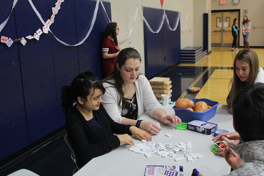 During the prom on Friday, Feb. 9, junior Makayla King and senior Stef Mayorga play with dominoes. 