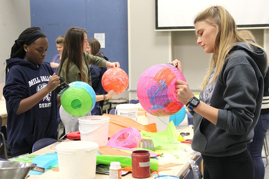 Spreading Mod Podge on a lantern, senior Bella Hadden makes a planet on Sunday, Jan. 28 that will be used for decoration at WOCO.
