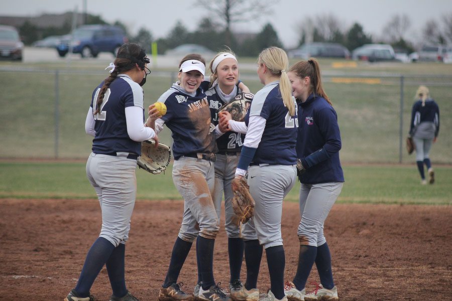 The infield celebrates with each other at their game against the Blue Valley West Jaguars on Tuesday, March 27.