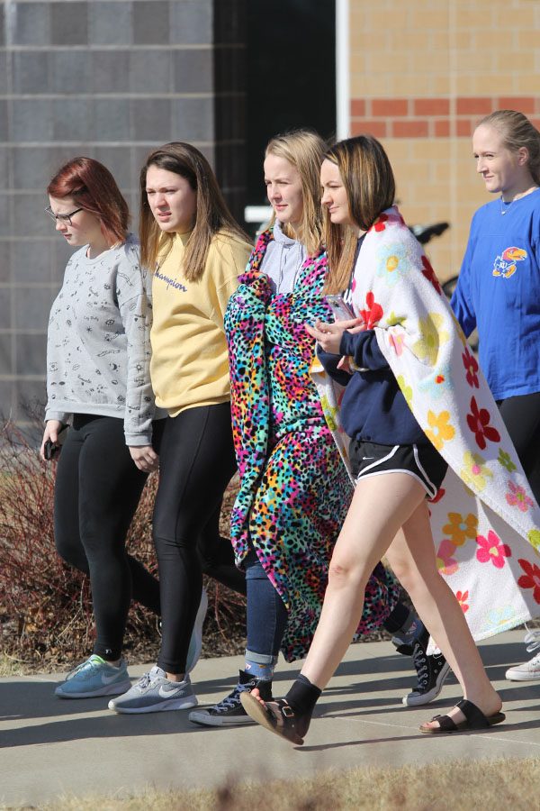Wrapped in a blanket, freshman Molly Smith walks out with friends. 