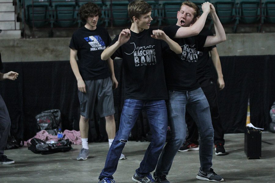 During a timeout, freshman Leif Campbell and senior Landon Butler dance along with the rest of the drumline. 