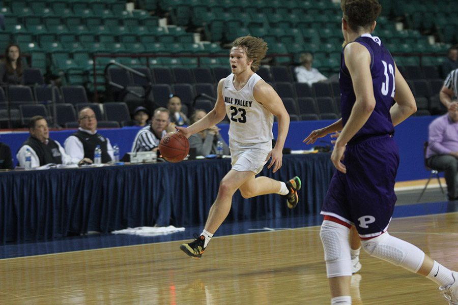 Dribbling down the court, senior Cooper Kaifes prepares to pass to a teammate. 