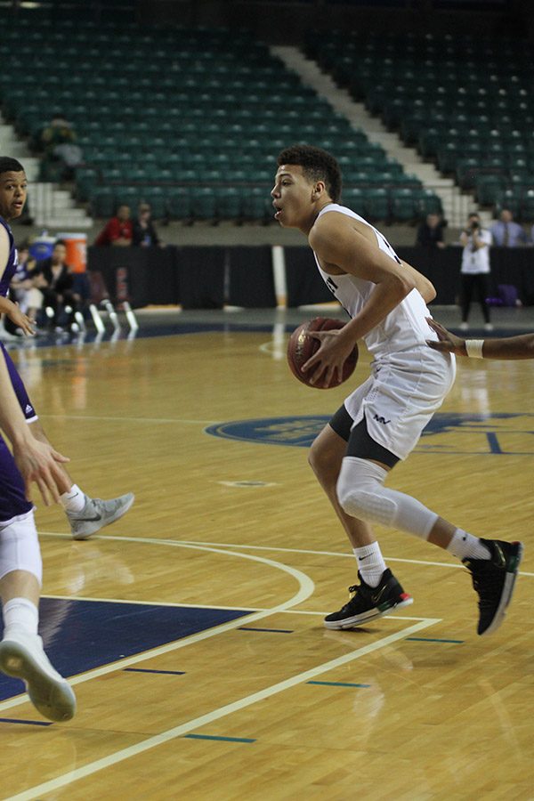 With his eyes on his opponents, junior Matty Wittenauer prepares to move to the basket to take a shot.